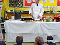 Kids look on as Mr. Grambo prepares the sauce...